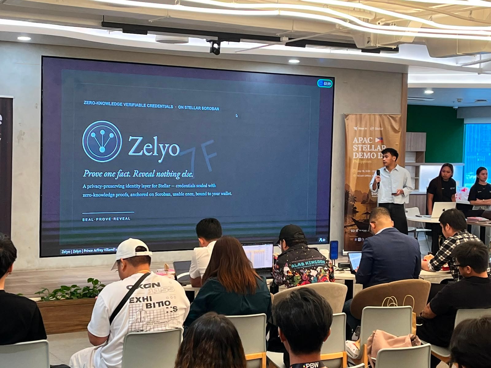 The Zelyo title slide — "Prove one fact. Reveal nothing else." — on screen during its Demo Day pitch