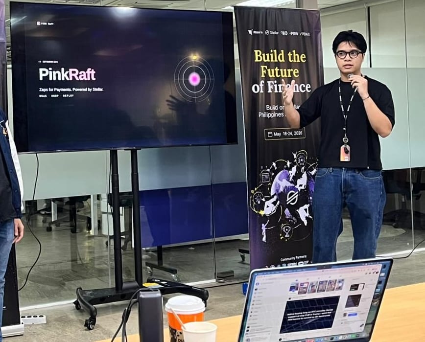 Carl Macabales pitching Pink Raft — "Zaps for Payments. Powered by Stellar." — beside the Build the Future of Finance banner at the Build on Stellar Philippines Hackathon, May 2026
